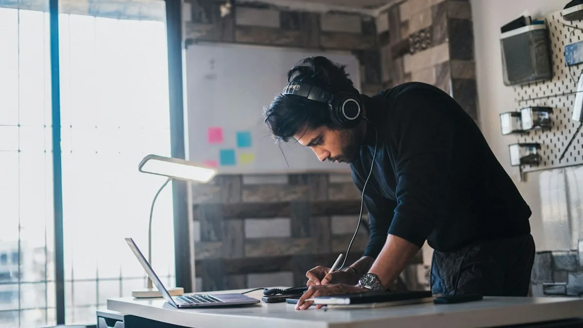 A man works at a desk with headphones