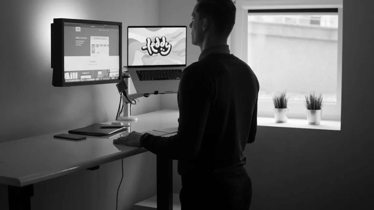 man in black long sleeve shirt standing in front of computer